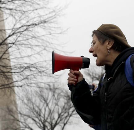 A woman shouts into a loudspeaker during a feminist rally.