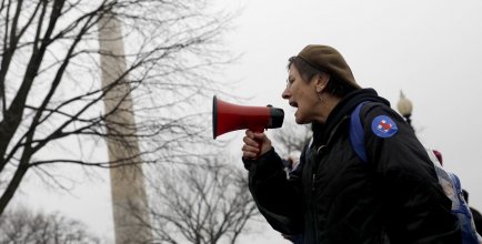 A woman shouts into a loudspeaker during a feminist rally.