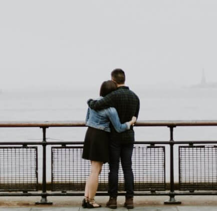 A couple hugging while looking at the ocean