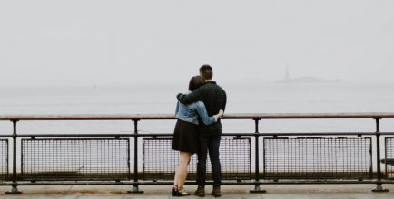 A couple hugging while looking at the ocean