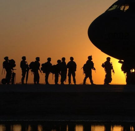 American Troops boarding a plane at dusk