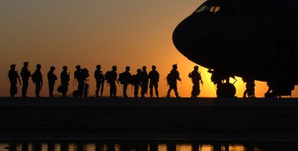 American Troops boarding a plane at dusk
