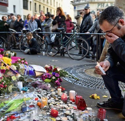 public gather to lay flowers and light candles following a suicide bomber attack