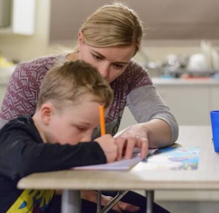 Mom does homework with her stepson Sam at the family home