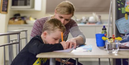 Mom does homework with her stepson Sam at the family home