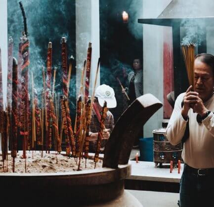 A religious ceremony practiced by an man holding incense