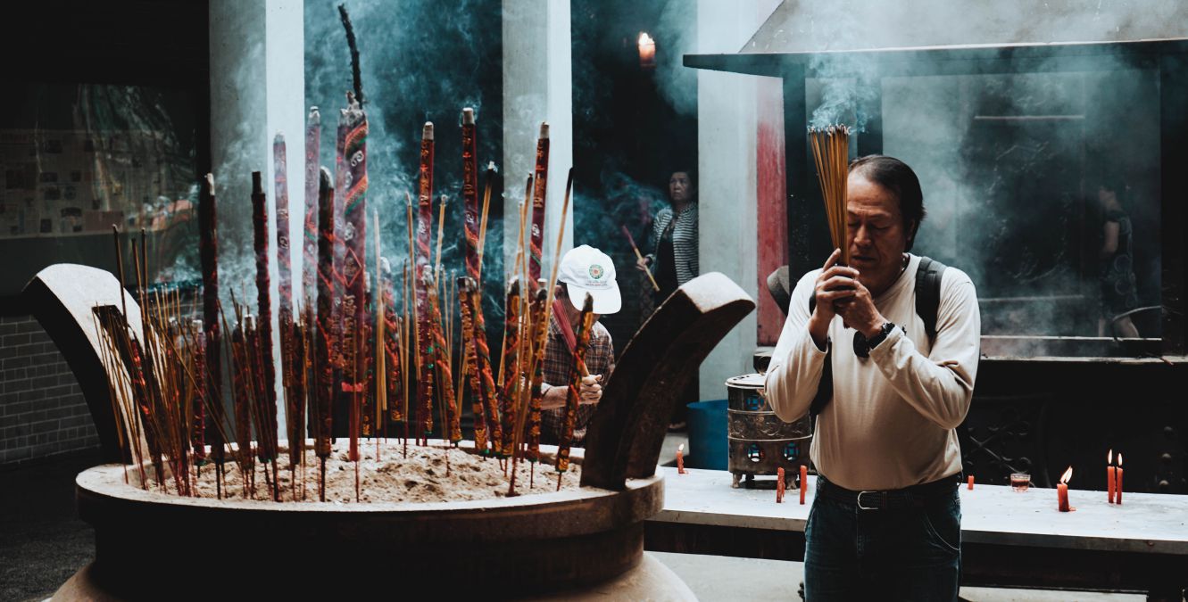 A religious ceremony practiced by an man holding incense