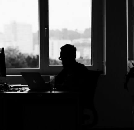 An intern sitting alone in the office, looking out the window