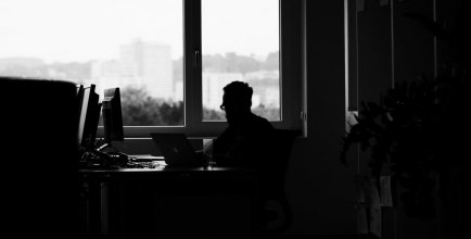An intern sitting alone in the office, looking out the window