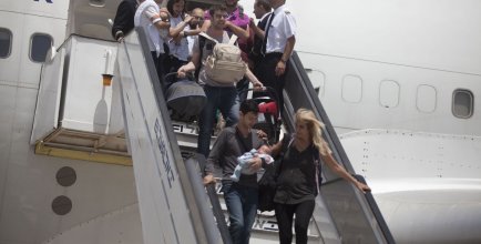 travelers with their new born babies from surrogate mothers in Nepal disembark from plane