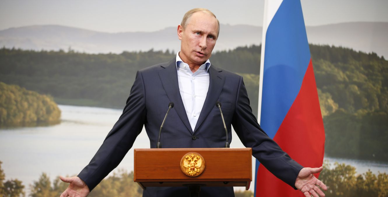 Vladimir Putin speaking at a podium.