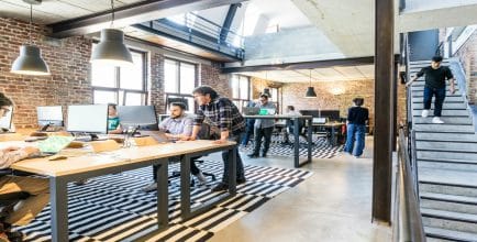 Workers in a startup company open-plan office environment working together.