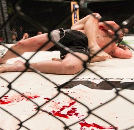 two MMA fighters on a bloody mat.